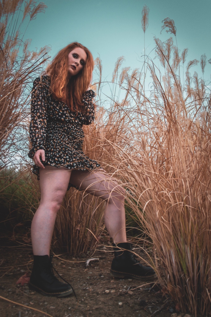 redhead woman standing in pampas grass